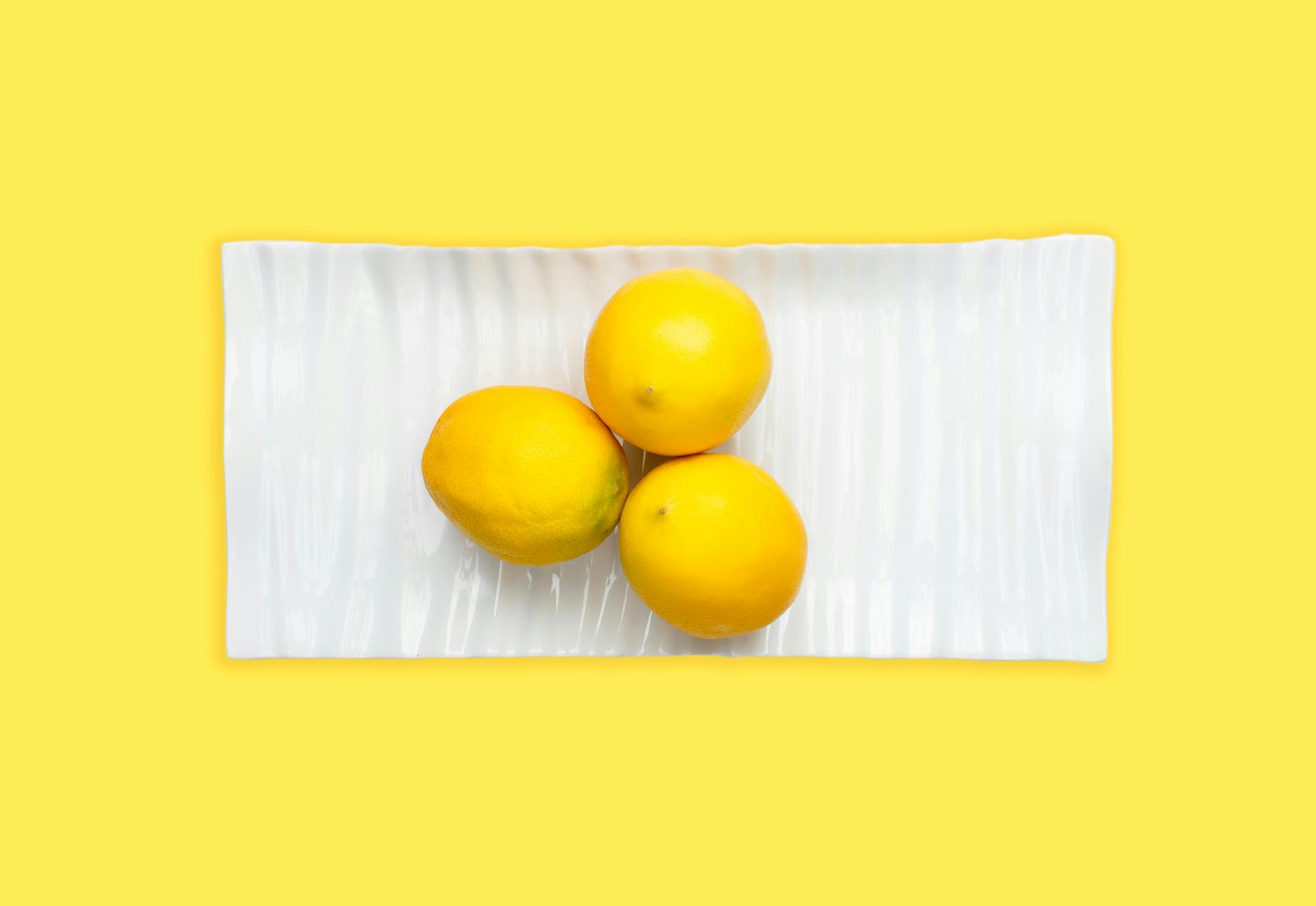 Fresh lemons arranged on a white plate, symbolizing self-care and natural pleasure