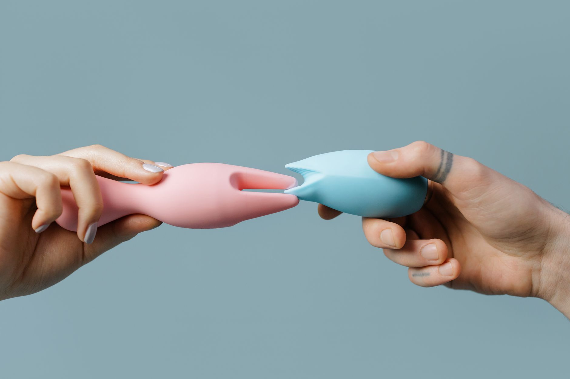 紫色の背景に握られた青いシリコン製バイブレーター
