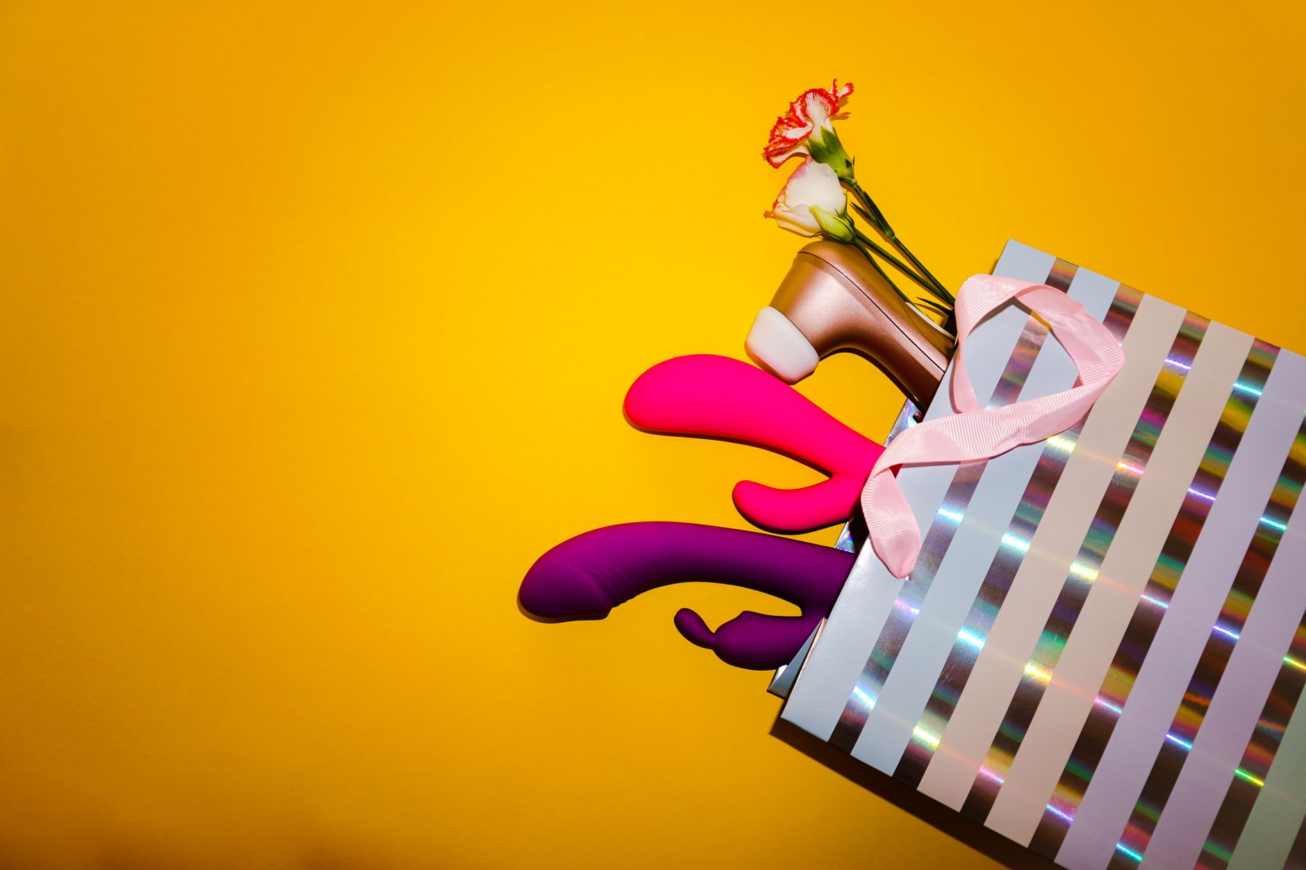 Yellow silicone lemon vibrator surrounded by peeled bananas on a yellow background